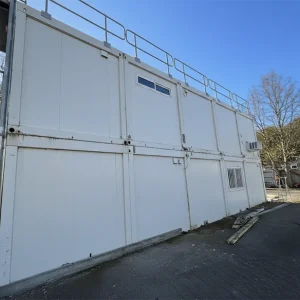 Base vie compagnon modulaire double hauteur en conteneurs blancs, vue extérieure sur chantier BTP
