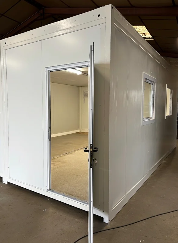 Bungalow de chantier d’occasion en cours d’aménagement, porte ouverte sur l’espace intérieur