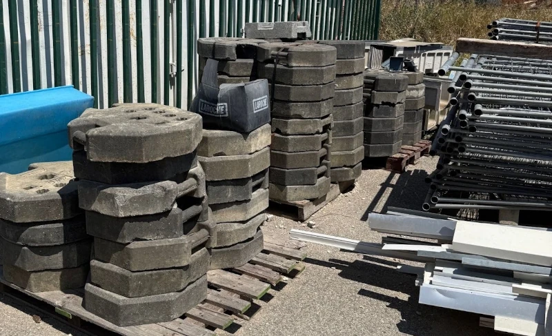 Barrières Héras de chantier empilées avec plots béton